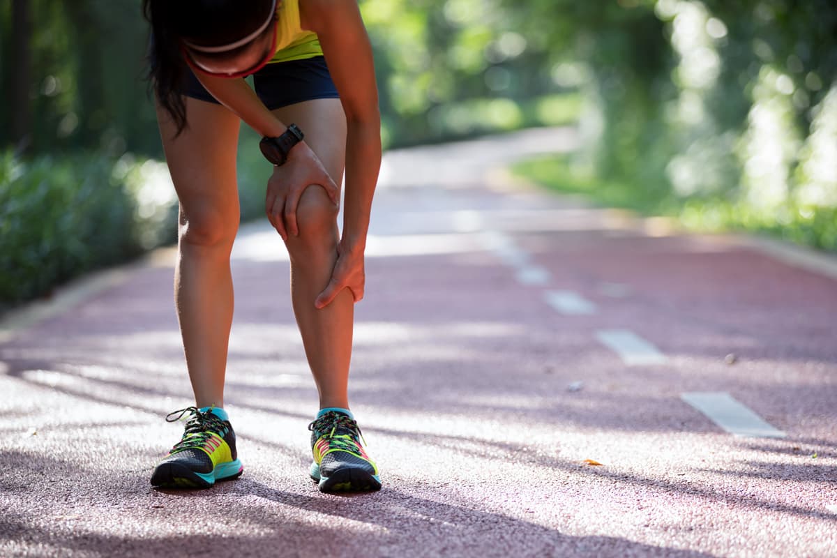 Jeune femme souffrant du genou pendant un footing