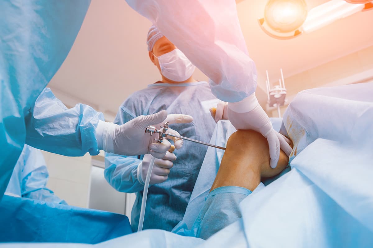 Chirurgien orthopédique en pleine intervention chirurgicale sur un genou après une entorse grave